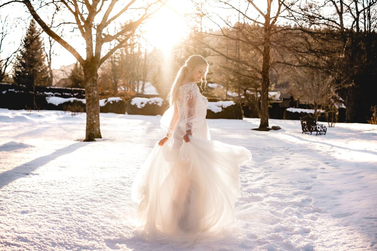 Wedding in winter - bride stands in the sunshine with a wonderful dress