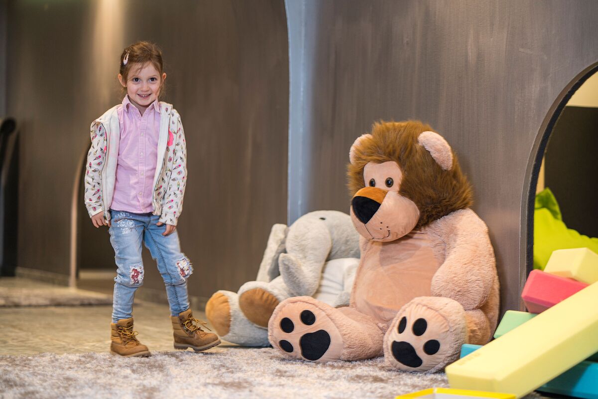 Indoor children's playground with standing, smiling girl