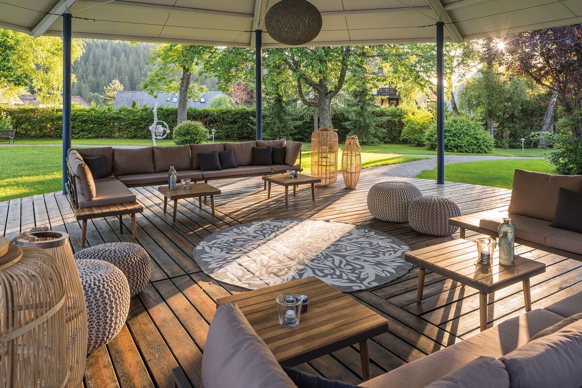 Outdoor wellness seating area with wooden floor and cozy couches