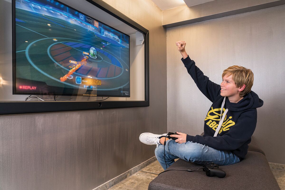 Teenage lounge with games console and cheering boy